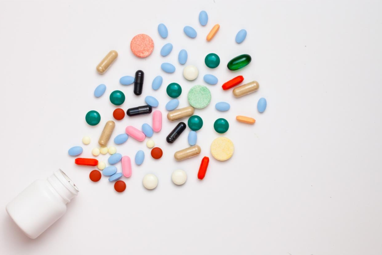 Artistic image of blank pill bottle with scattered pills