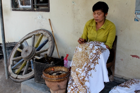 Indonesian woman applying wax to Batik cloth