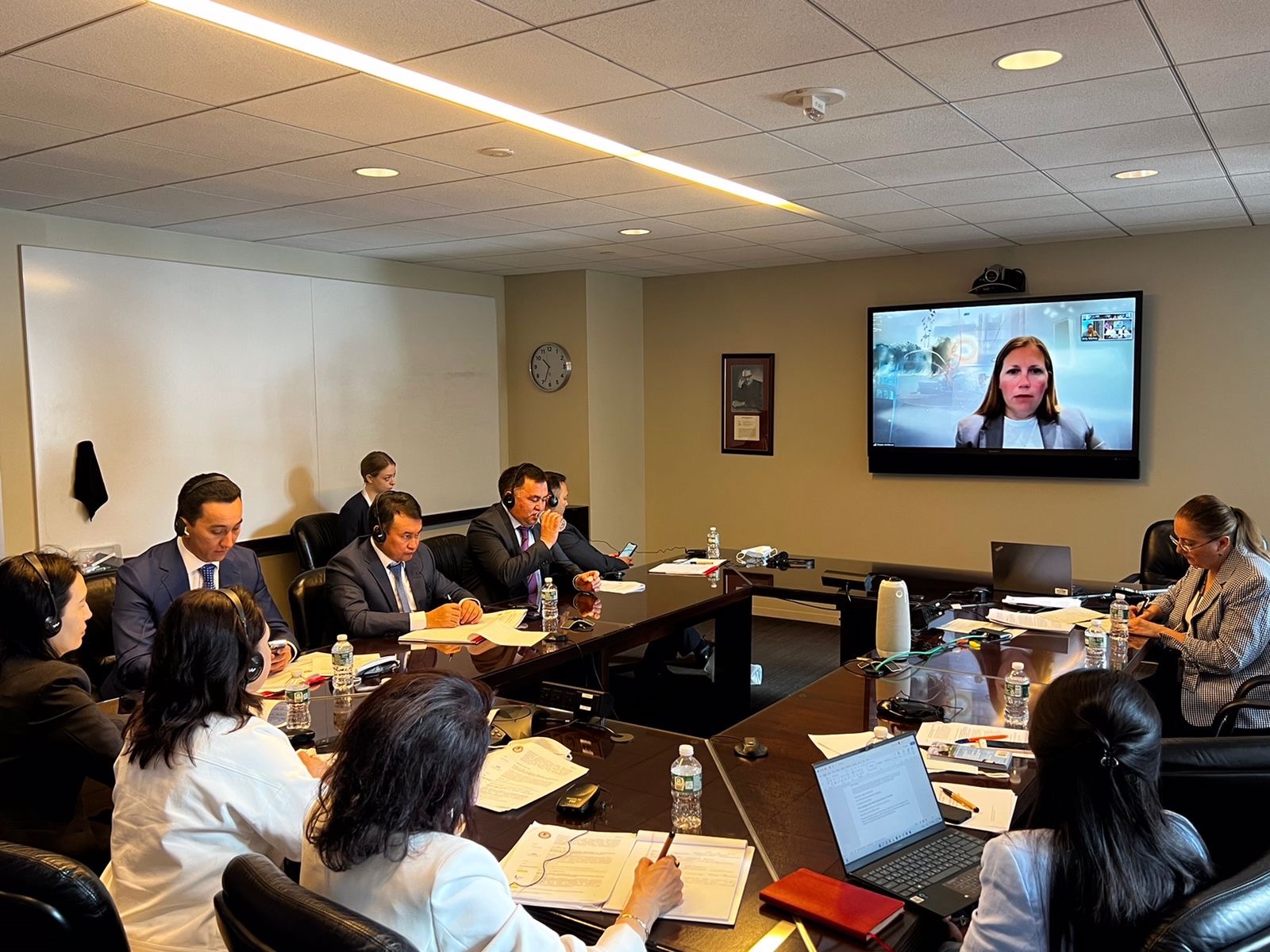 Conference room at the American Bar Association DC office. Judges and ABA-ROLI staff are gathered around a conference table listening to the Mid-Atlantic Innocence Project's Executive Director speak over Zoom.