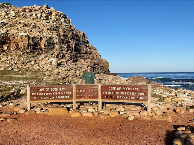Law student standing behind sign that says "Cape of Good Hope"