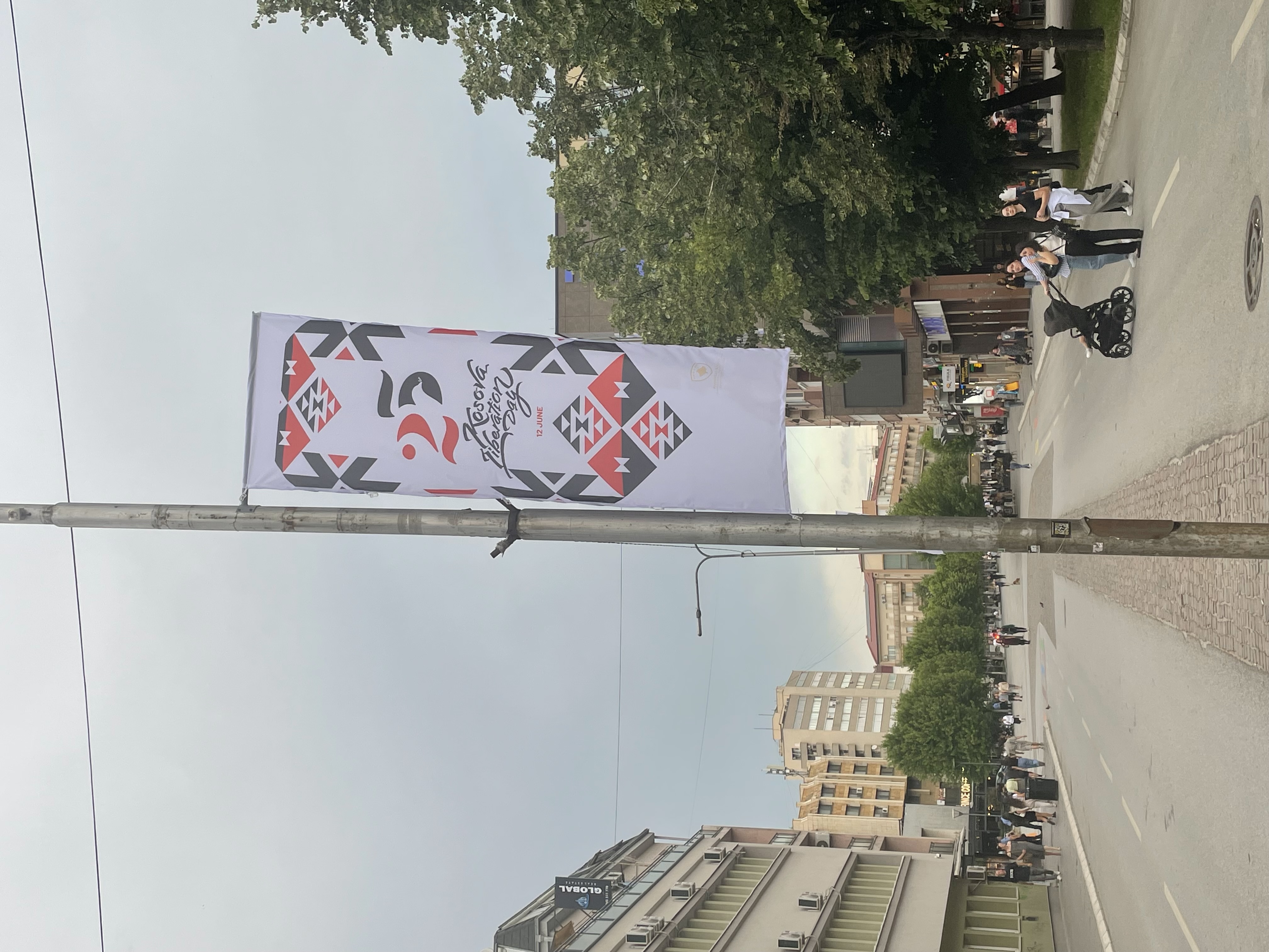 A banner downtown that says "Kosova Liberation Day" and "June 12" with the number 25.