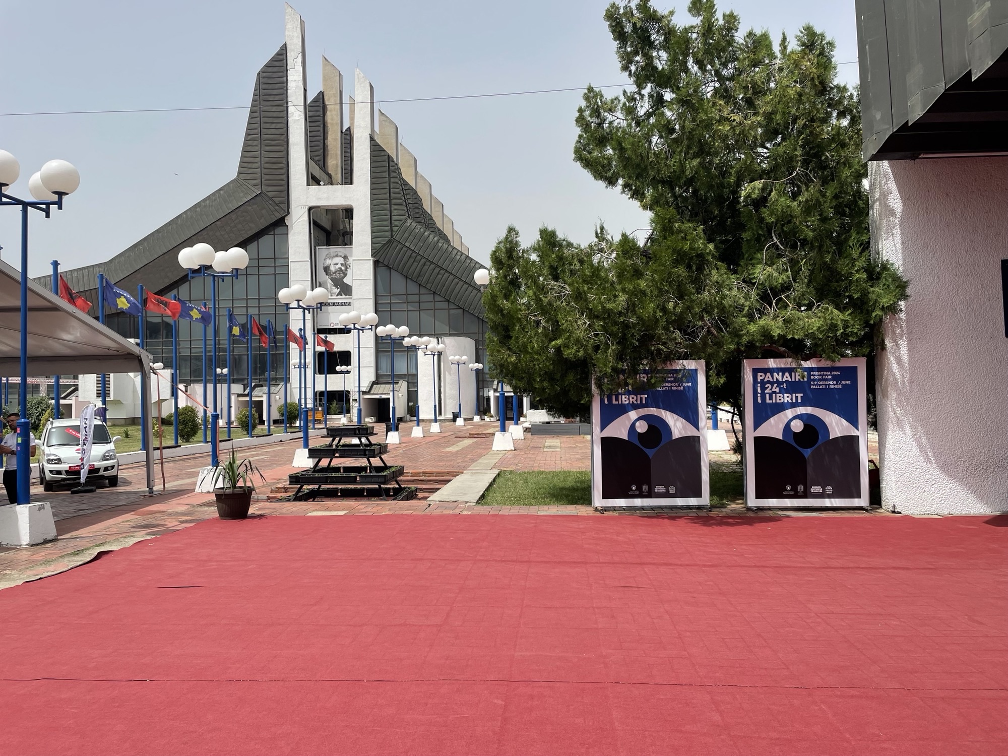 The outside of the Palace of Youth and Sports, with two signs for the Pristina Book Fair.