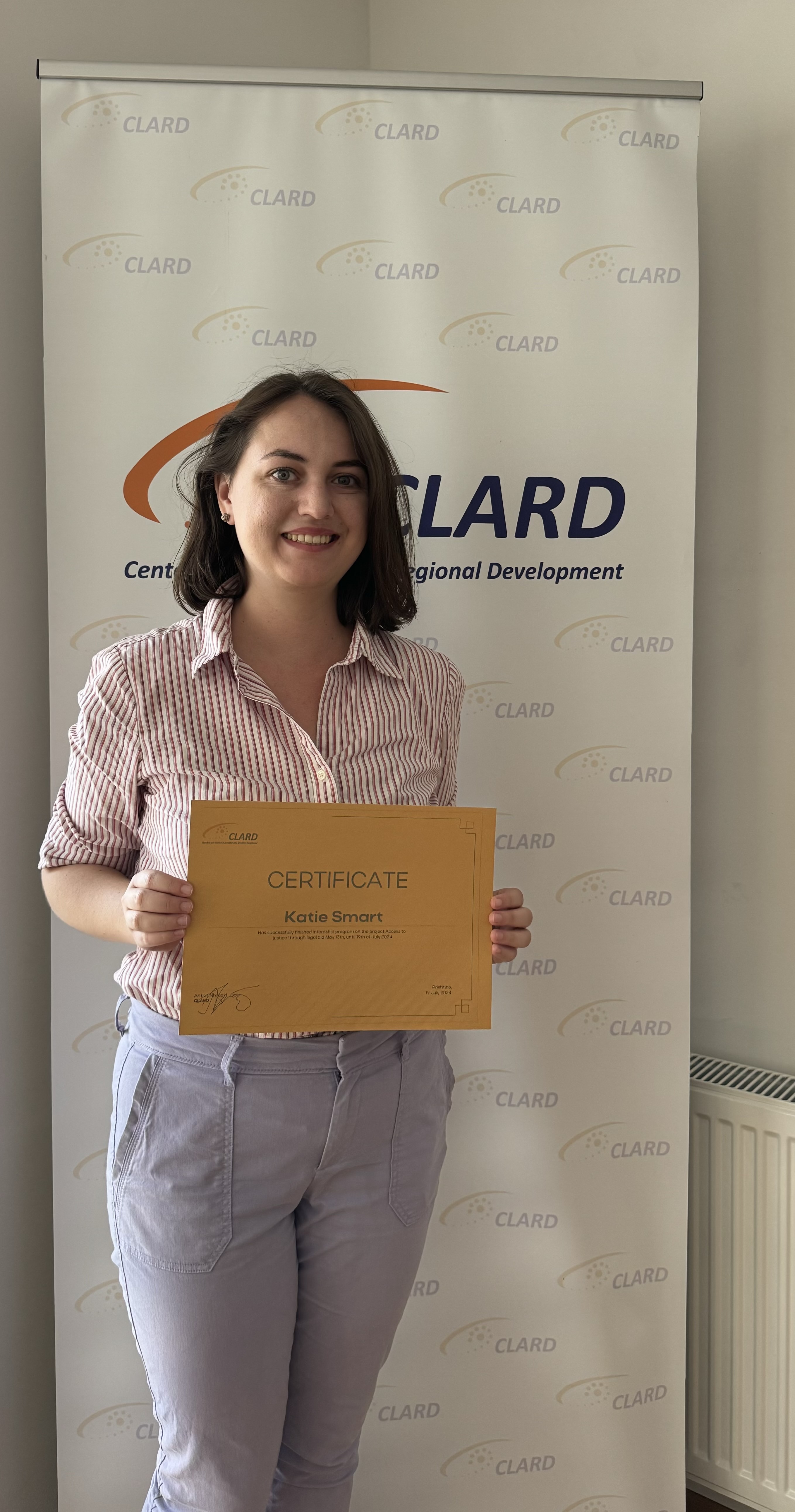 Me, in front of the CLARD banner with the certificate my coworkers gave me before leaving.