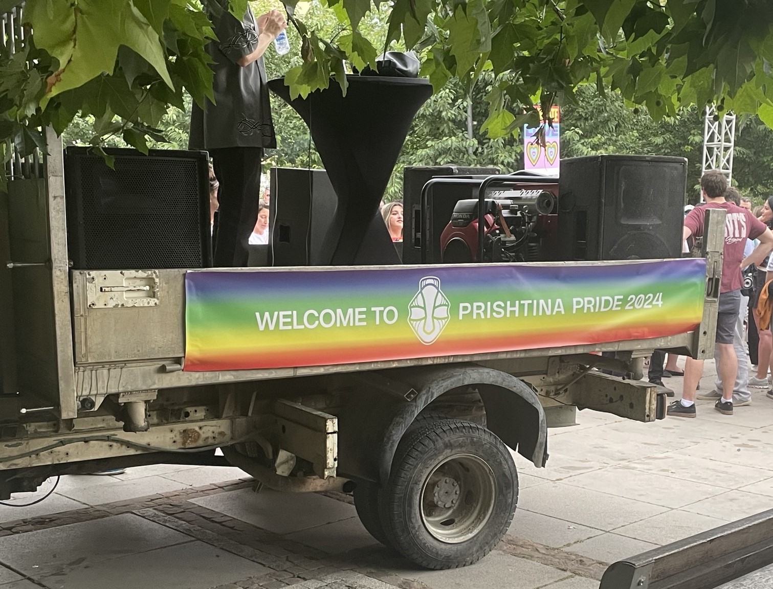 A rainbow sign at the pre-parade rally that says, "Welcome to Prishtina Pride 2024."
