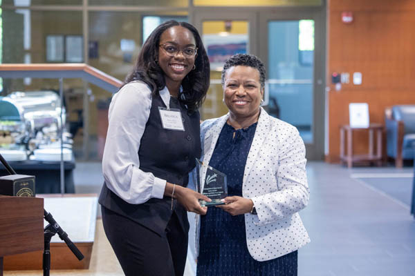 2025-26 BLSA President Breanca White ’27 presents the Honorable Carla Archie ’95 with the BLSA Distinguished Alum Award in recognition of her illustrious career. Photo: David F. Morrill